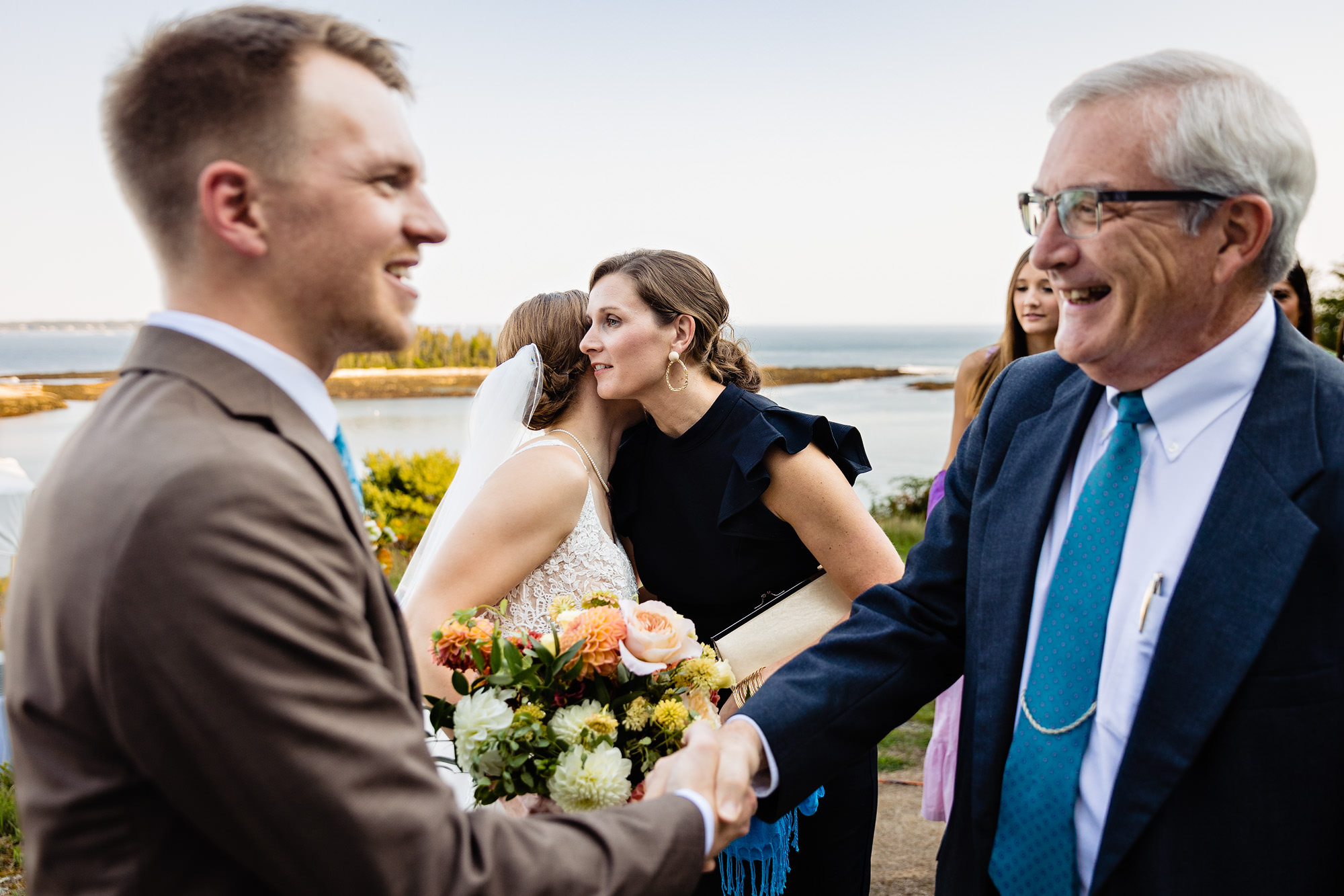 Hugs after a stunning coastal wedding ceremony in Georgetown, Maine