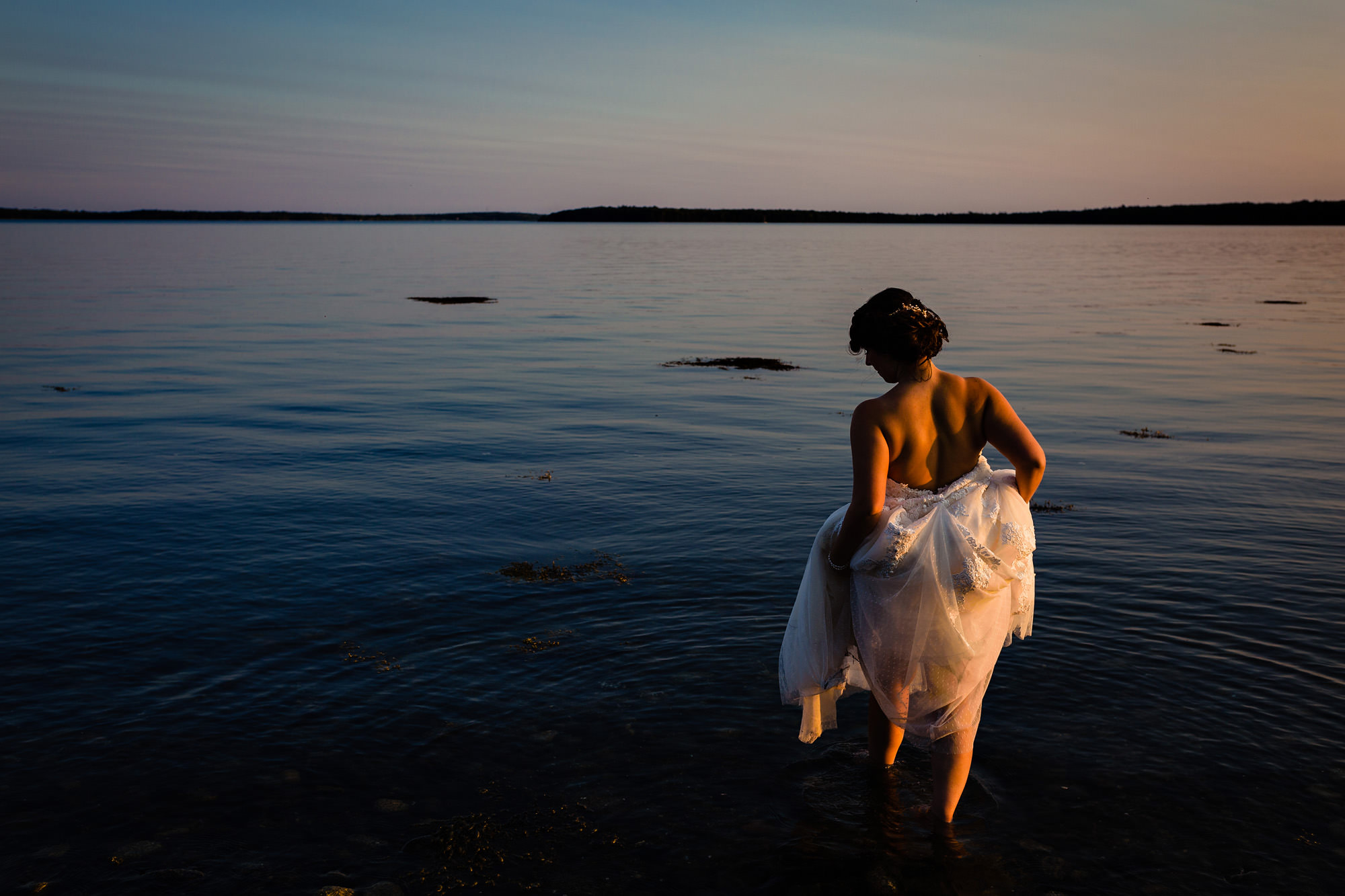 A bride walks into the ocean on her wedding day.