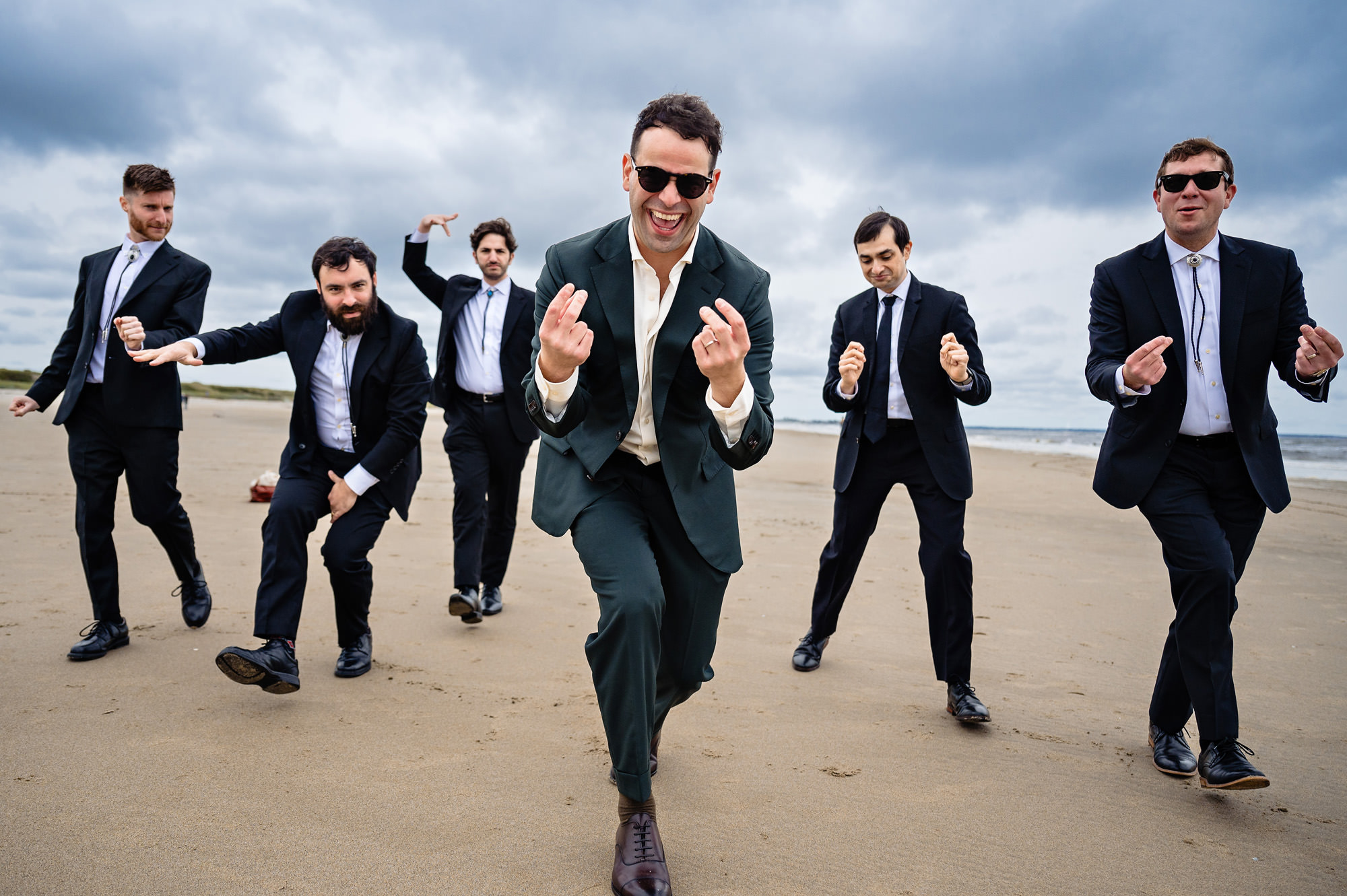 The groom and his groomsmen play around on the beach before his southern Maine wedding.