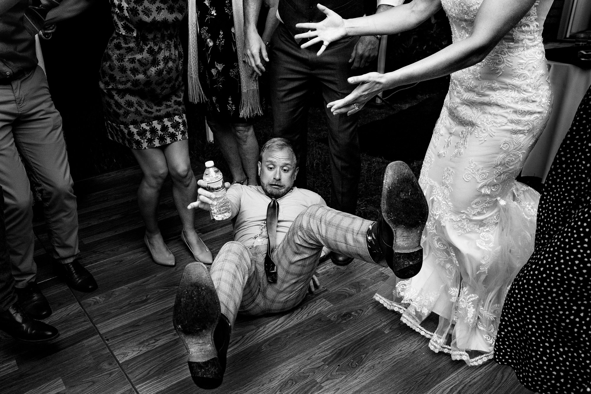 Newlyweds dancing joyfully with friends at their wedding reception.