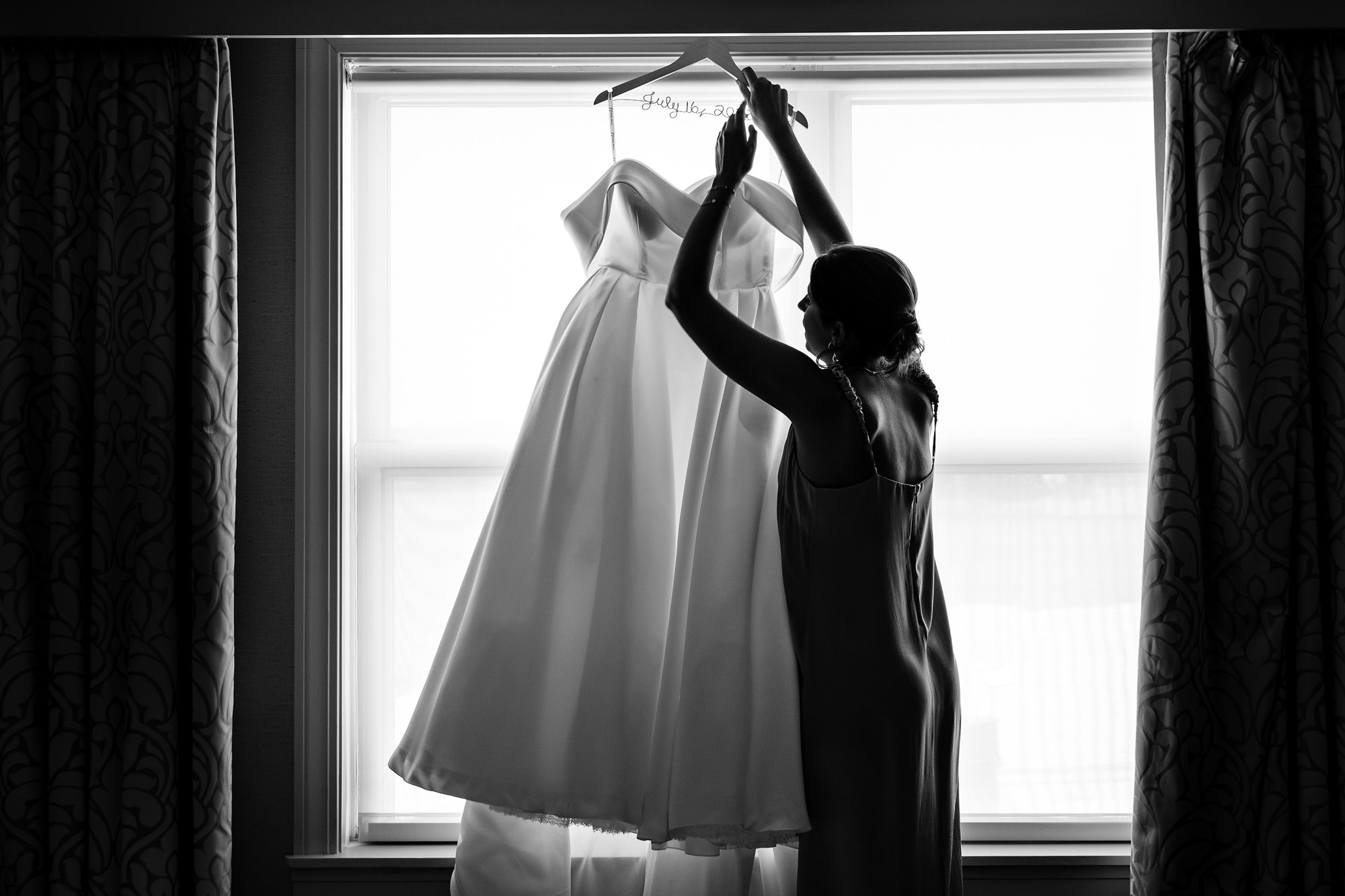 A bridesmaid grabs the wedding dress for the bride to change into.