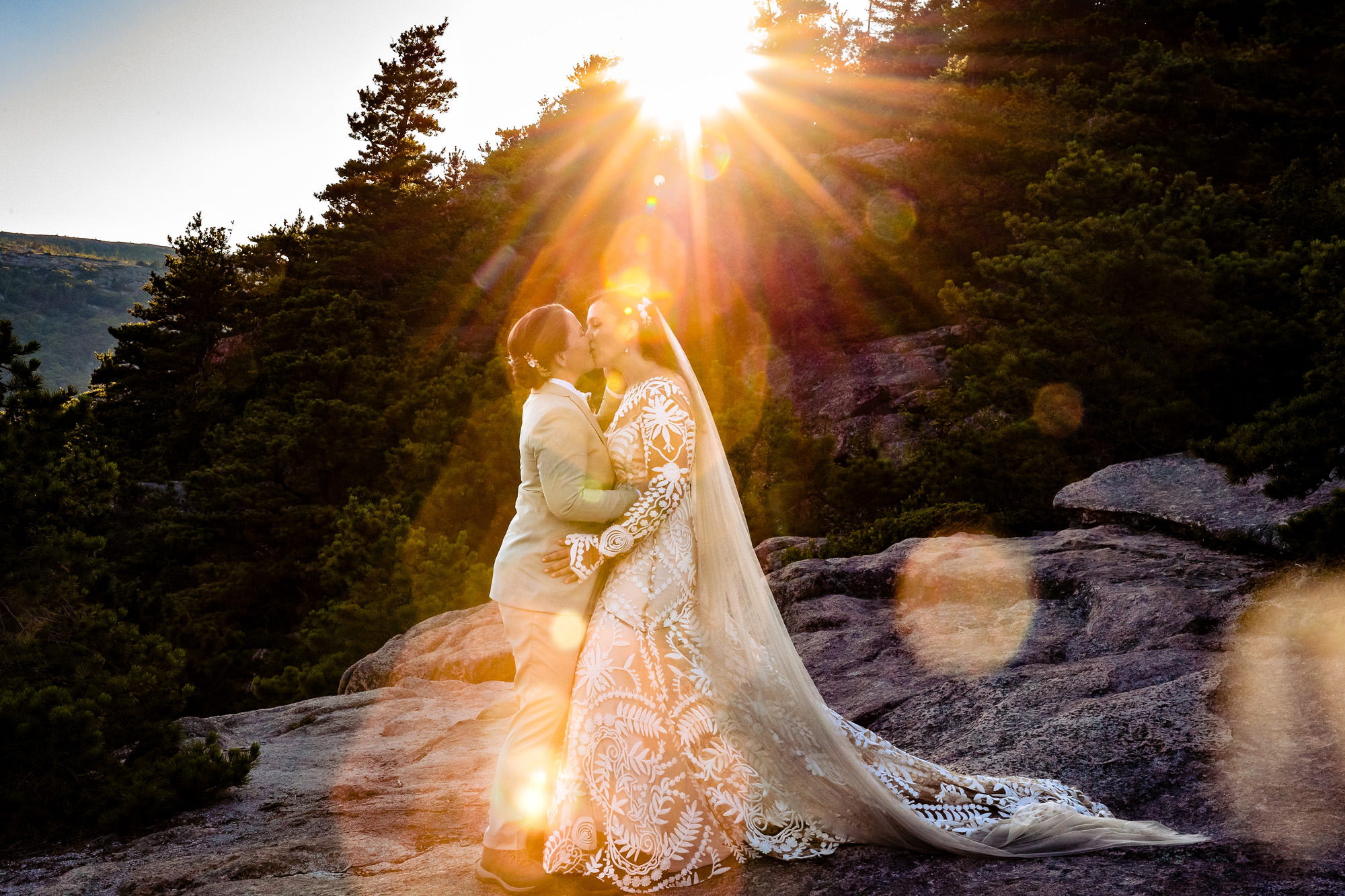 A backlit wedding portrait of two brides during golden hour.