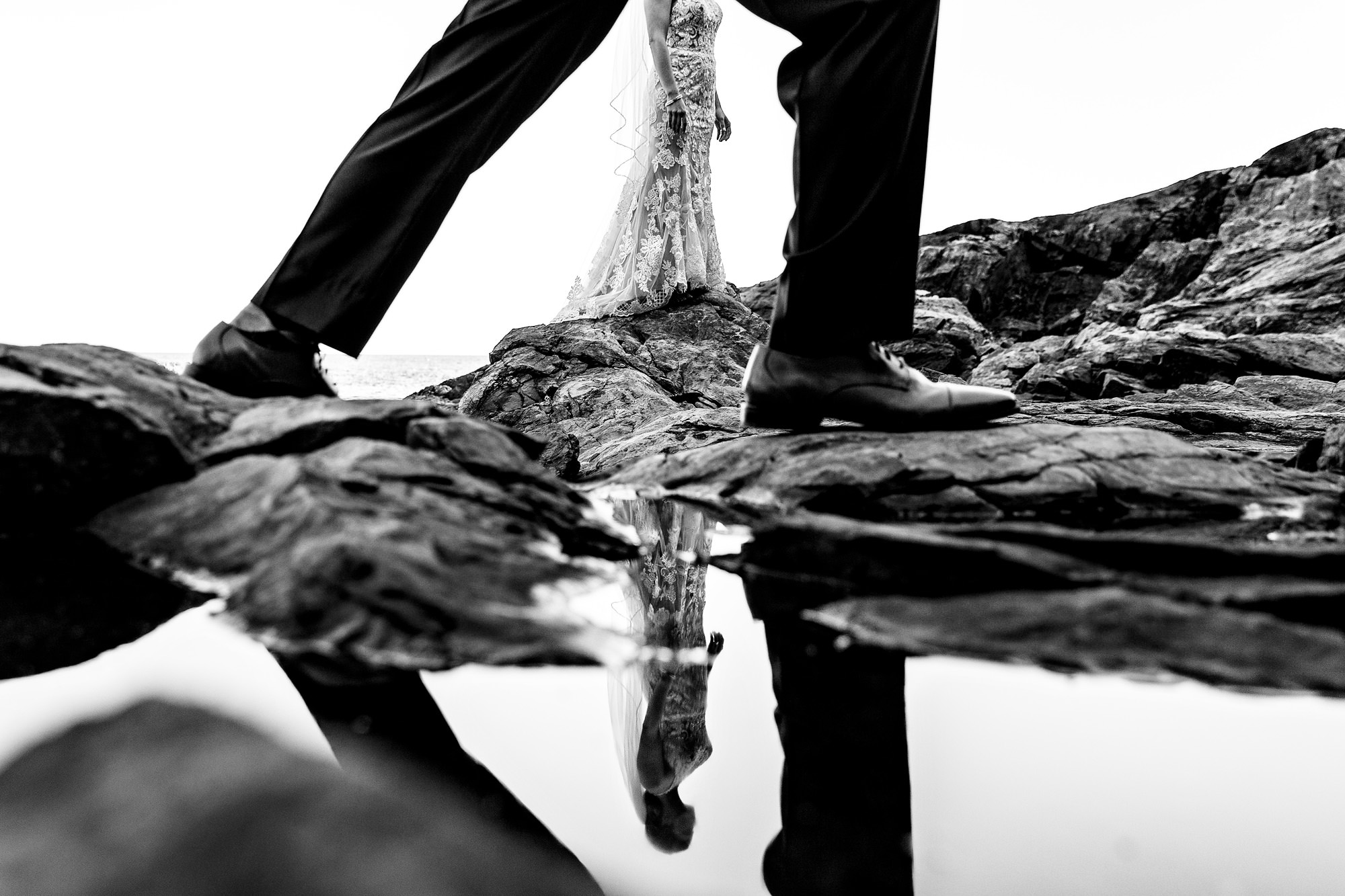 An abstract wedding portrait taken with the reflection of a tidal pool.