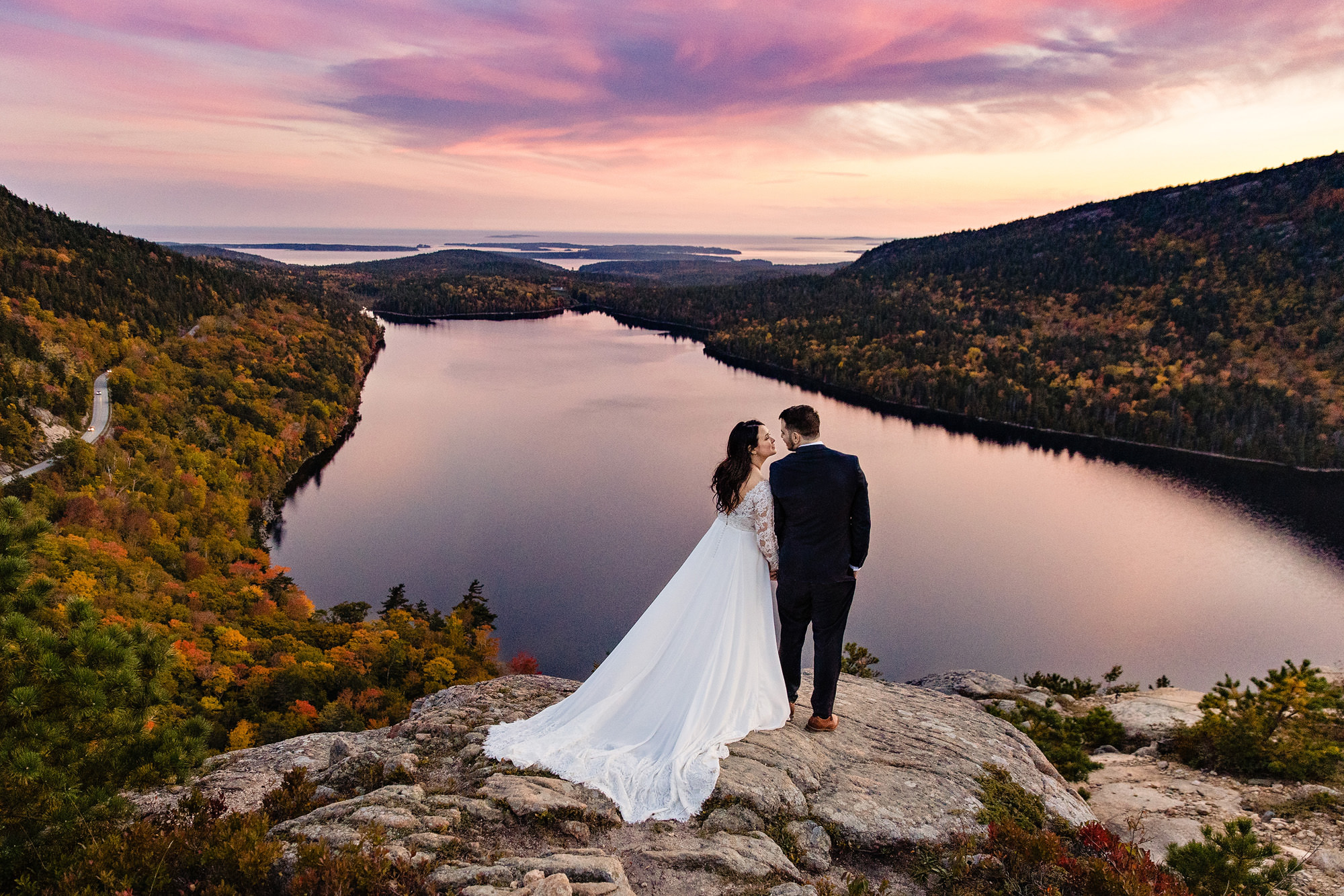 A wedding portrait taken on top of a mountain in Acadia at sunset.