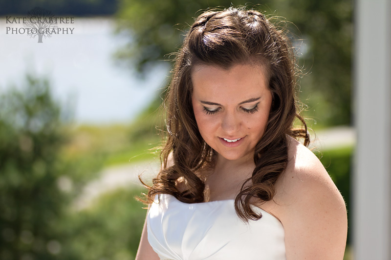 The bride poses in front of the Atlantic ocean as she waits for her Winterport Winery wedding to begin.