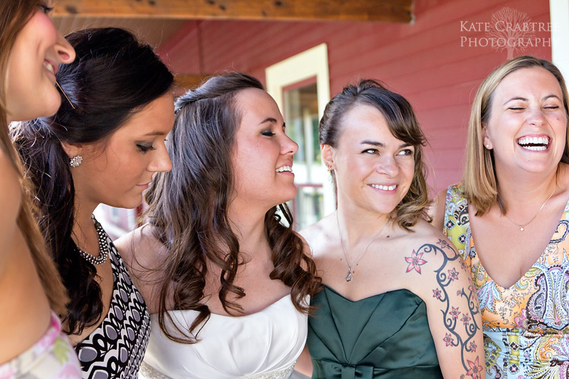 The bride and her friends share a naturally lit candid moment at the Winterport Winery