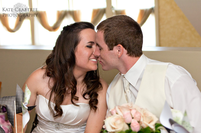 The bride and groom share a small kiss at the Winterport Winery in Maine.