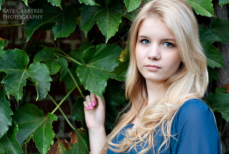 High school senior Grace Eye poses during her portrait session in Orono Maine in front of a wall of ivy.