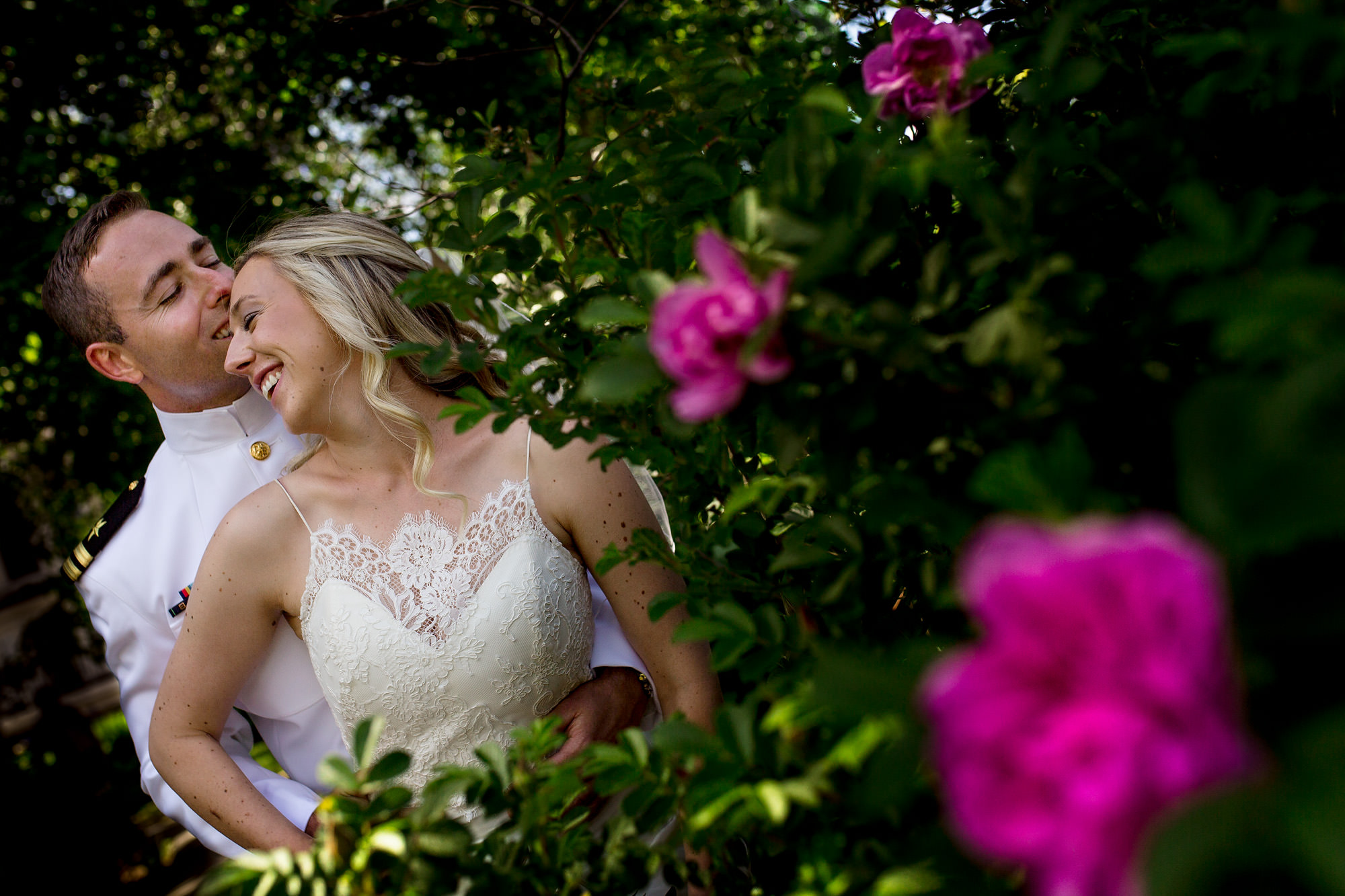 A bride and groom wedding portrait in front of flowers in Camden, Maine