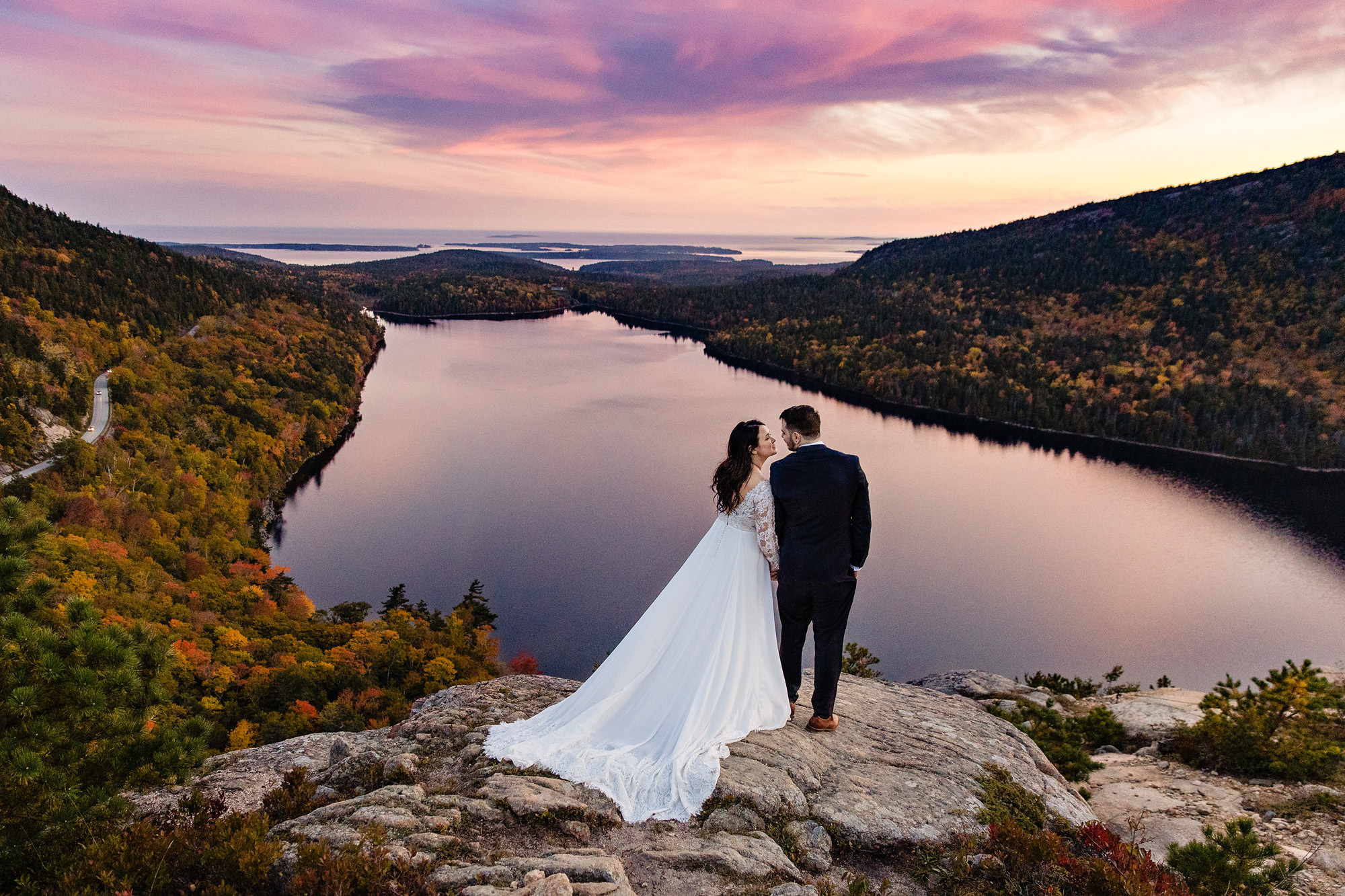 A bride and groom on top of a mountain in Acadia National Park