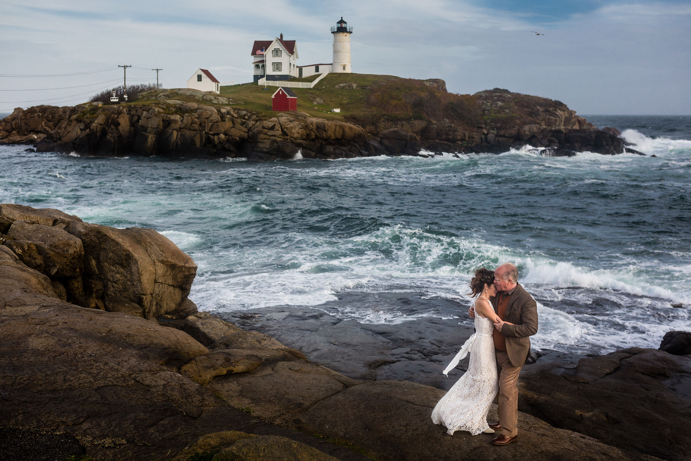 A bride and groom embrace at their elopement at Nubble Lighthouse in York, Maine