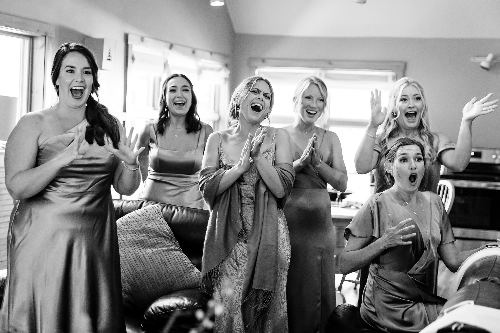 Bridesmaids react enthusiastically when they see the bride for the first time in her wedding dress.