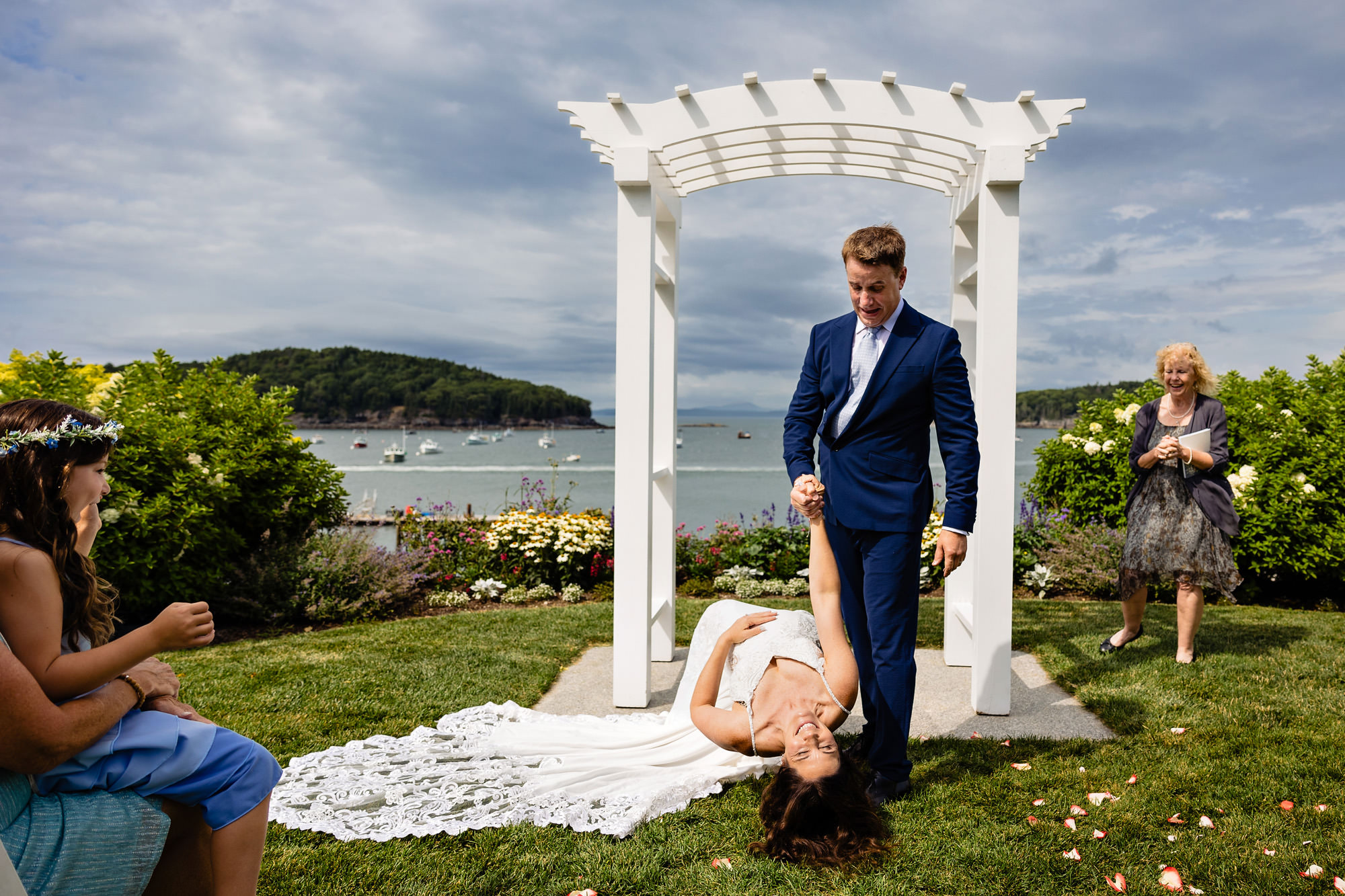 A wedding couple does a unique dip after their first kiss at their Bar Harbor Inn wedding