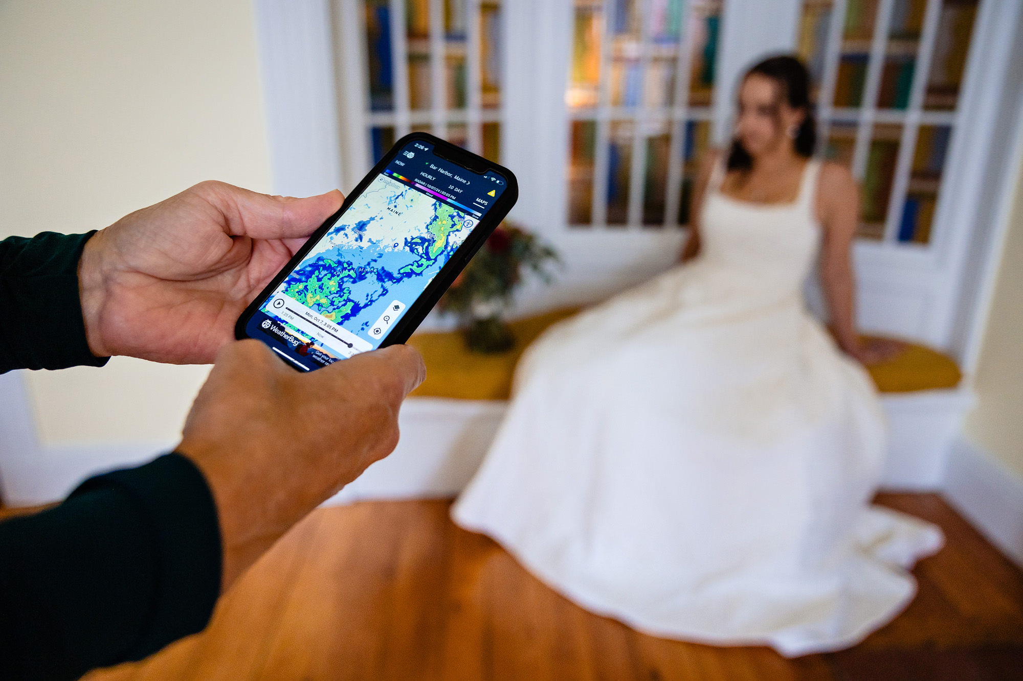 Someone checks the weather radar at a wedding in Bar Harbor, Maine