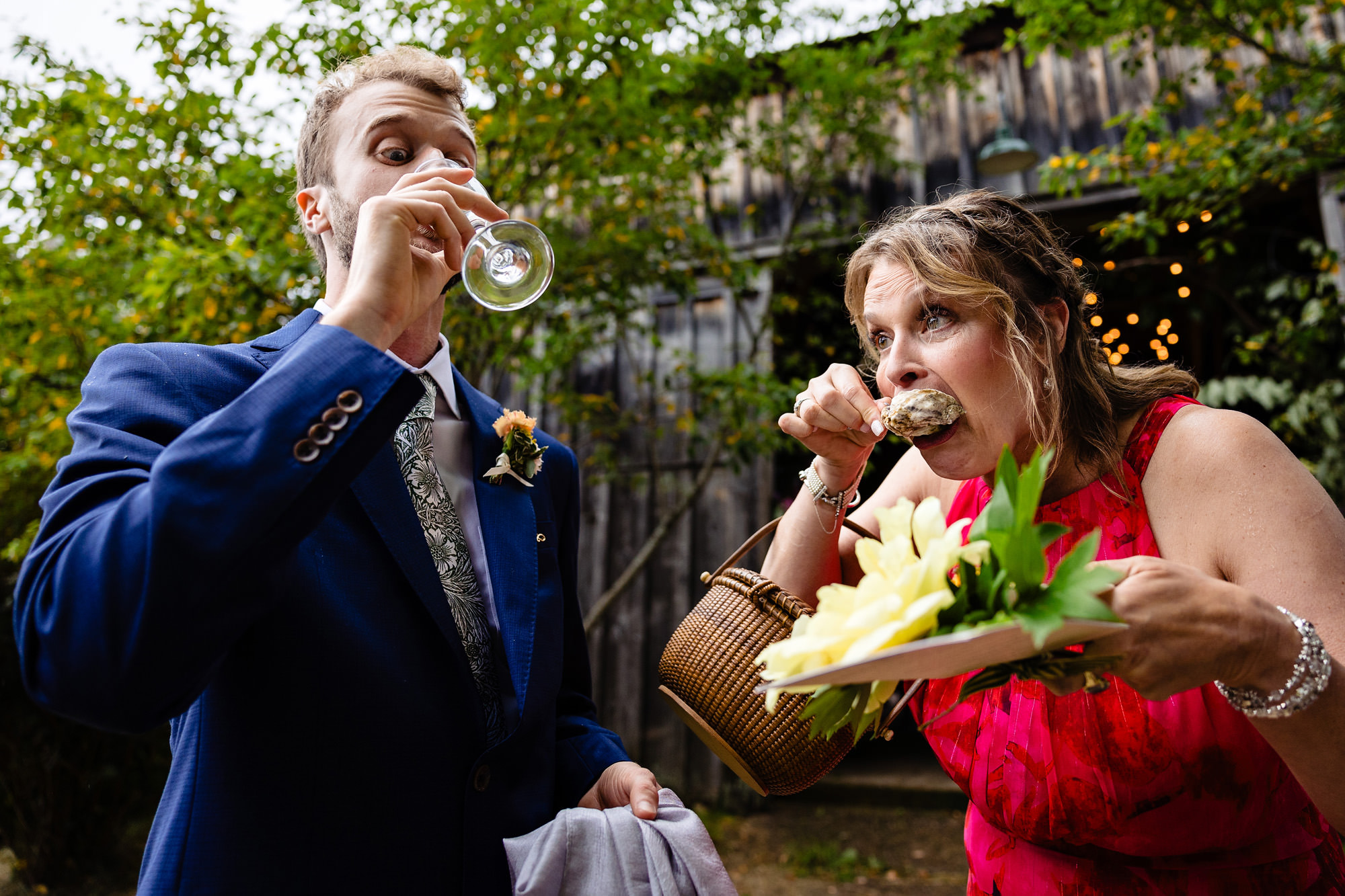 A groom and his mom eat and drink during cocktail hour in this funny photo from a Broadturn Farm wedding