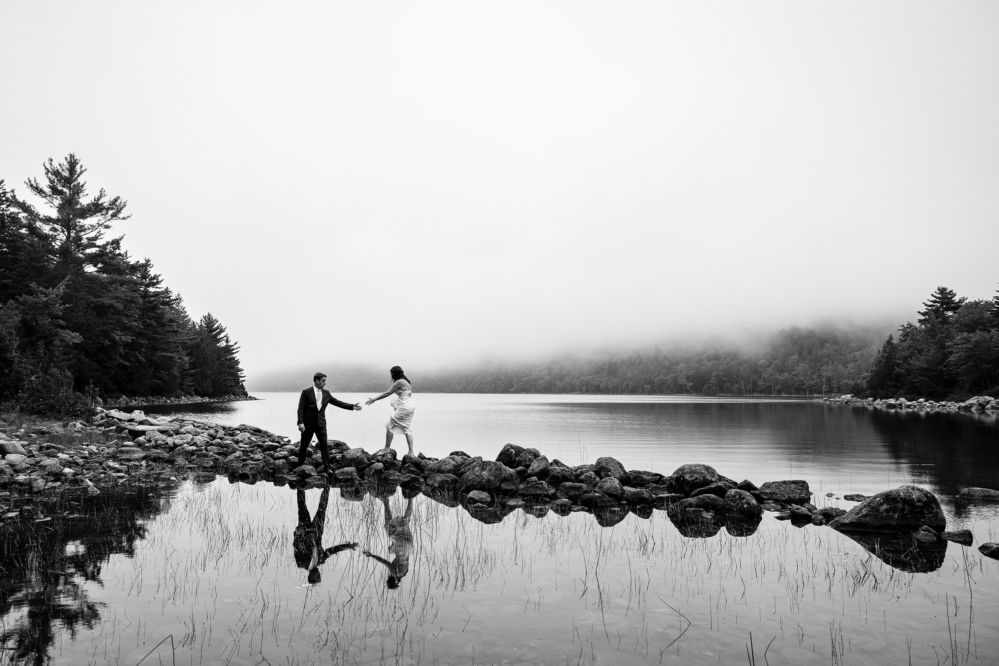 A wedding couple walks to a spot so they can create a portrait in Acadia National Park