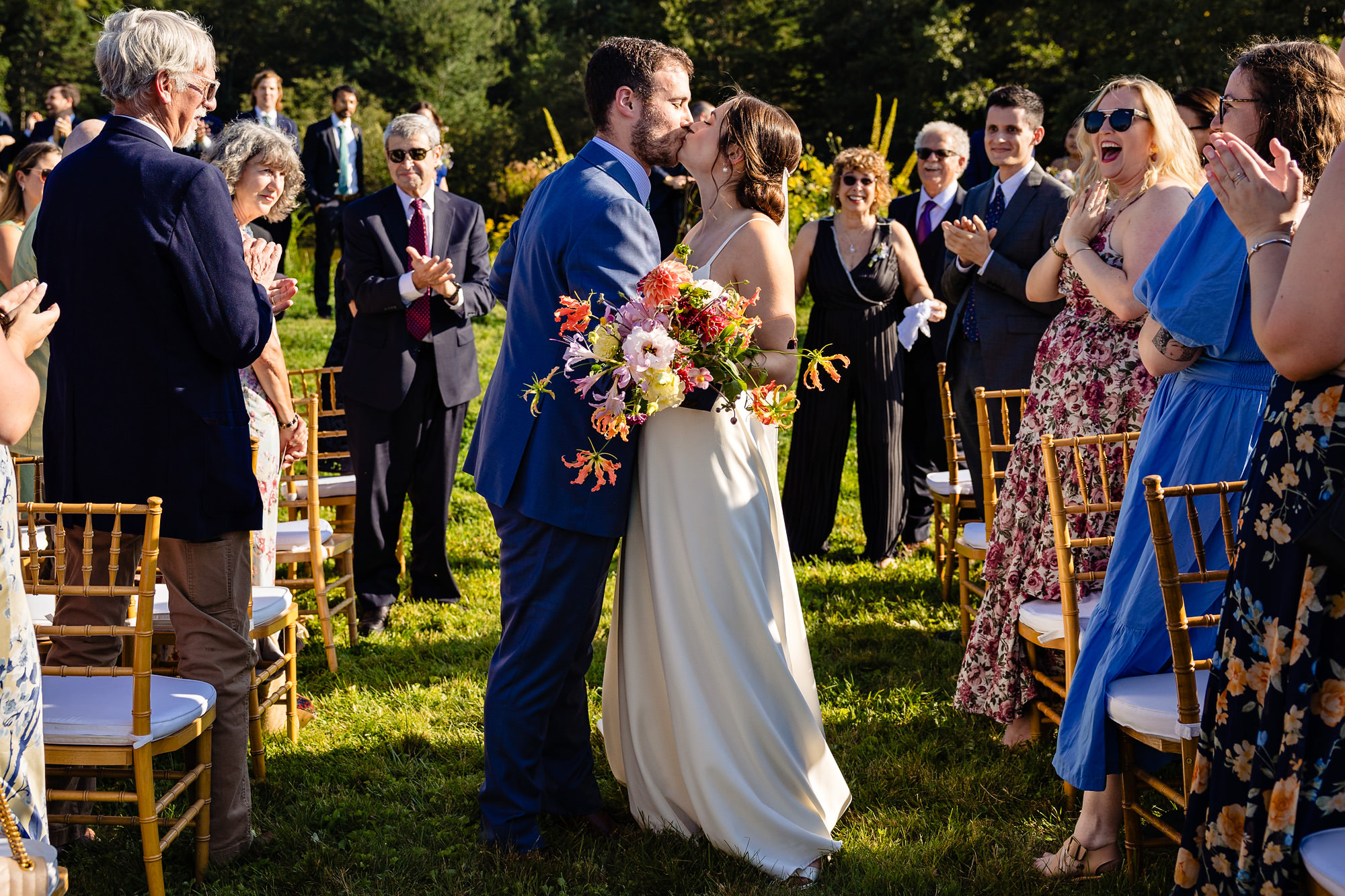 A wedding couple kiss in the middle of the aisle at their Sweet Pea's Cafe wedding