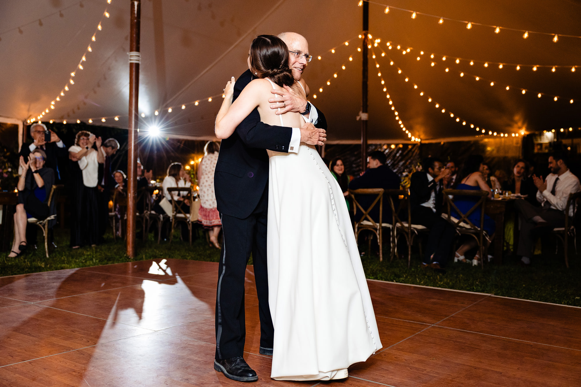 The father of the bride hugs the bride after thair father daughter dance at her Bar Harbor Sweet Pea's Cafe wedding